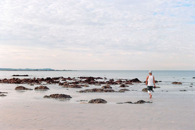 Scenic view of rocks on beach against sky