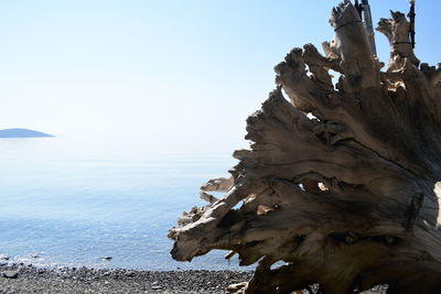 Rock formation on beach against clear sky