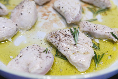 Chicken breast with olive oil and rosemary in pan