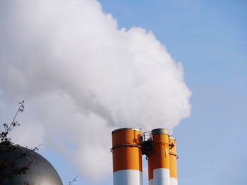 Smoke emitting from chimney against sky