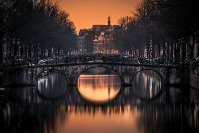 Arch bridge over canal in amsterdam at sunrise