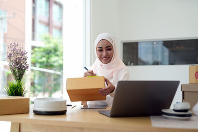 Young woman using laptop at table