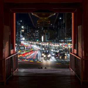 Cars on road in illuminated city at night