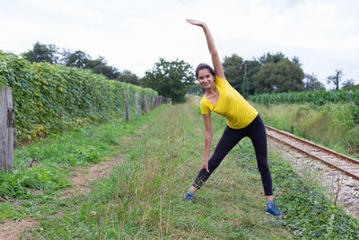 Full length of woman exercising on field