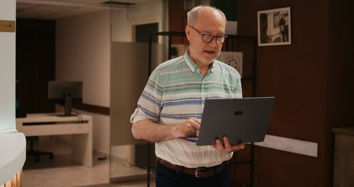 Portrait of man using laptop at home