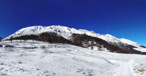 Snowcapped mountains against clear blue sky