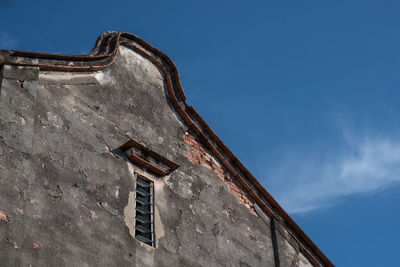 Low angle view of old building against blue sky