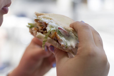 Cropped image of woman holding burger