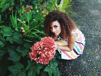 Portrait of beautiful woman by red flowering plants