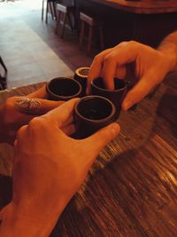 Cropped hand holding coffee on table