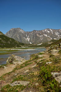 Scenic view of snowcapped mountains against clear blue sky