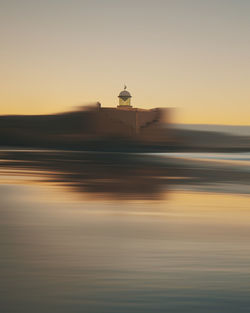 Blurred motion of building against sky during sunset