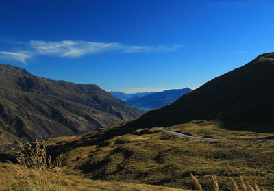 Scenic view of mountains against blue sky