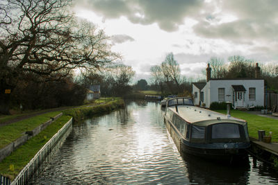 Canal amidst buildings in city against sky