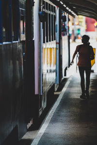 Rear view of man standing on railroad station platform