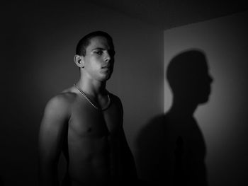 Portrait of serious shirtless man standing in room