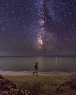 Scenic view of sea against star field at night