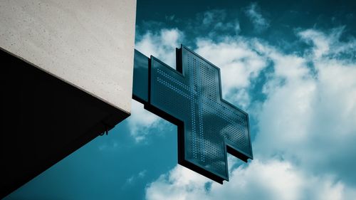 Low angle view of sign on building against sky