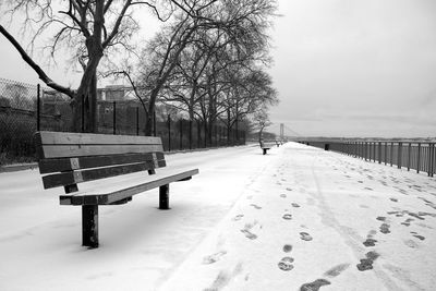 Rear view of person on bench in park during winter