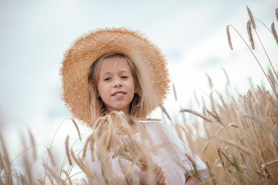 Portrait of young woman wearing hat against sky