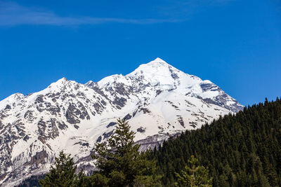 Scenic view of snowcapped mountains against blue sky