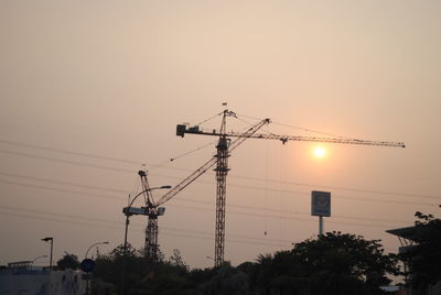 Low angle view of silhouette electricity pylon against sky