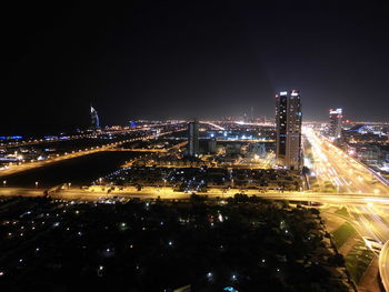 Illuminated cityscape against sky at night