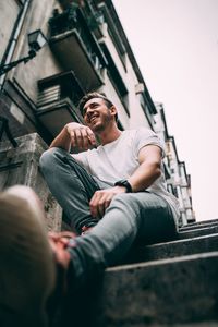 Low angle view of man sitting on staircase