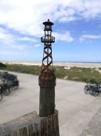 Lighthouse by sea against sky