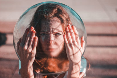 Close-up of portrait young woman wearing glass helmet in head during sunny day