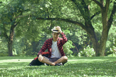 Full length of senior man sitting on grass