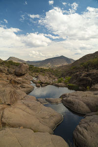 Scenic view of river and mountains against sky
