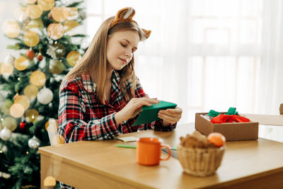 A cute teenage girl puts a letter with wishes for christmas or new year in an envelope