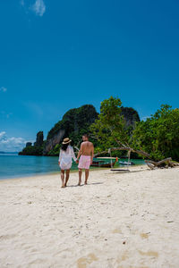 People at beach against blue sky