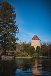 Lake by building against clear blue sky