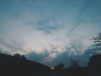 Low angle view of trees against sky at sunset