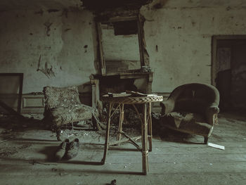 Rear view of woman sitting in abandoned house