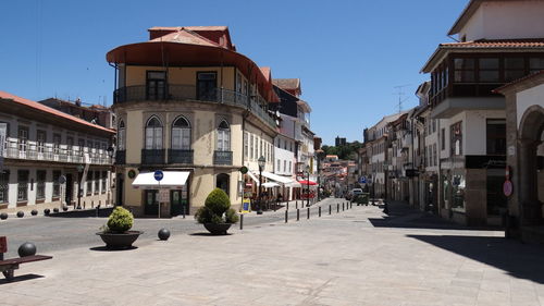 Street amidst buildings in town against clear sky