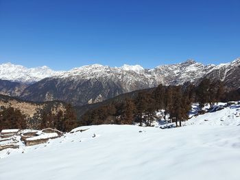 Scenic view of snowcapped mountains against clear sky