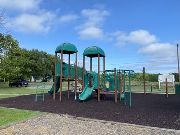 View of playground in park against blue sky