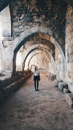 Rear view of man standing by old building