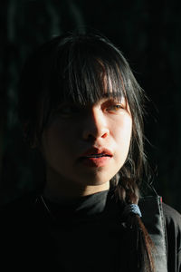 Close-up of woman against black background