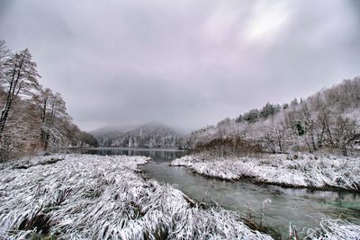 Scenic view of river against sky during winter