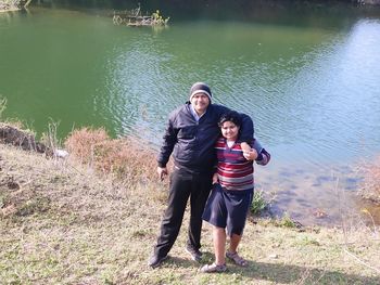 Full length portrait of happy friends standing in lake