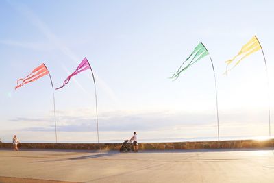 Low angle view of flags on road amidst field against sky