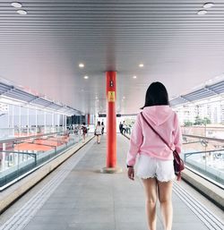 Rear view of woman standing on railroad station