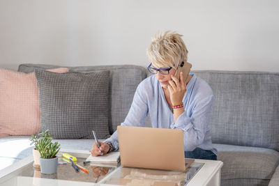 Woman using laptop on couch at home