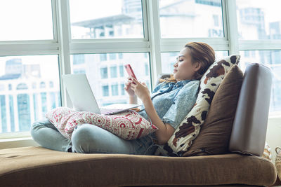 Woman sitting on sofa at home