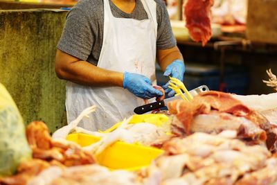 Midsection of man preparing food for sale at market stall