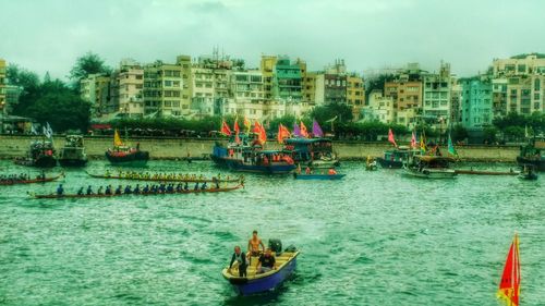 Boats in river with city in background